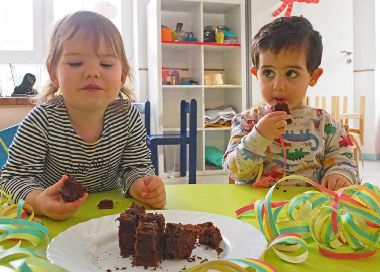 kinder-essen-schokoladenkuchen-am-tisch