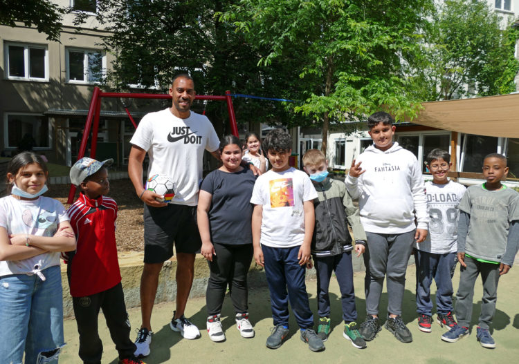 eine kindergruppe und ihr trainer schauen in die kamera
