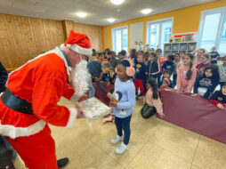 Ein als Nikolaus verkleideter Mann überreicht einem Kind ein Geschenk