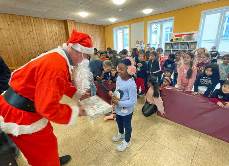 Ein als Nikolaus verkleideter Mann überreicht einem Kind ein Geschenk