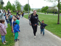 Kinder und Erzieherinnen laufen über einen Parcours